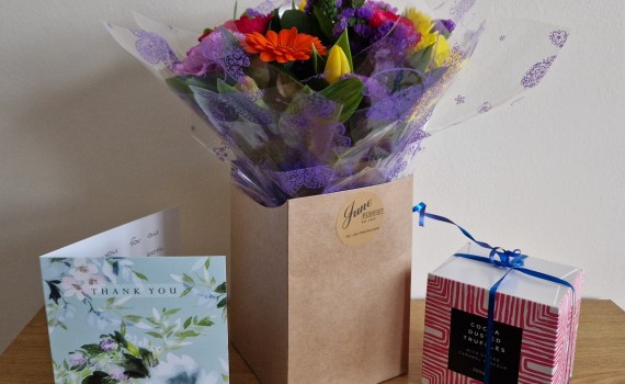 Photograph of flowers, chocolates and a thank you card